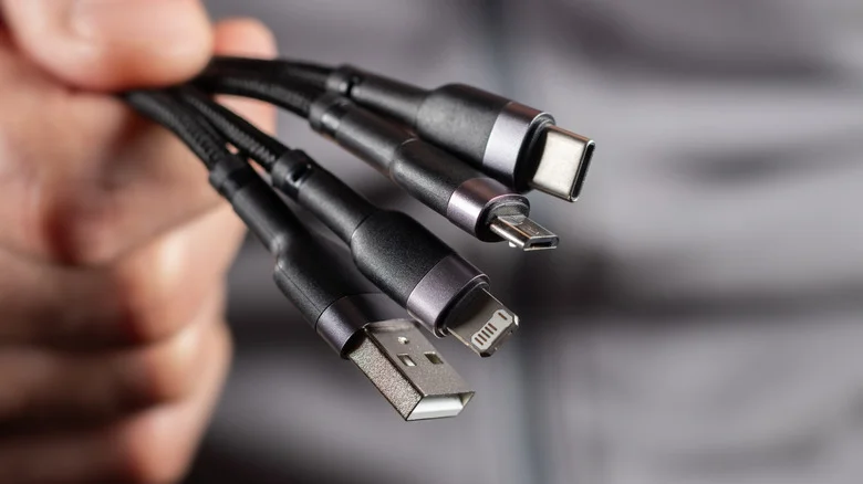 Many types of USB cables held in a hand