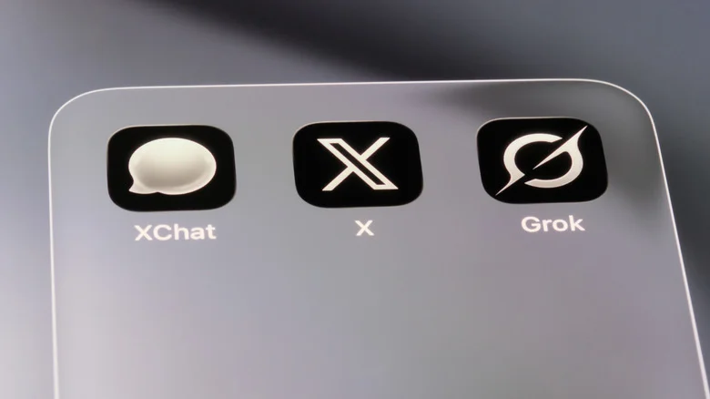Close-up view of a smartphone screen displaying the Grok app, the X app and XChat app.