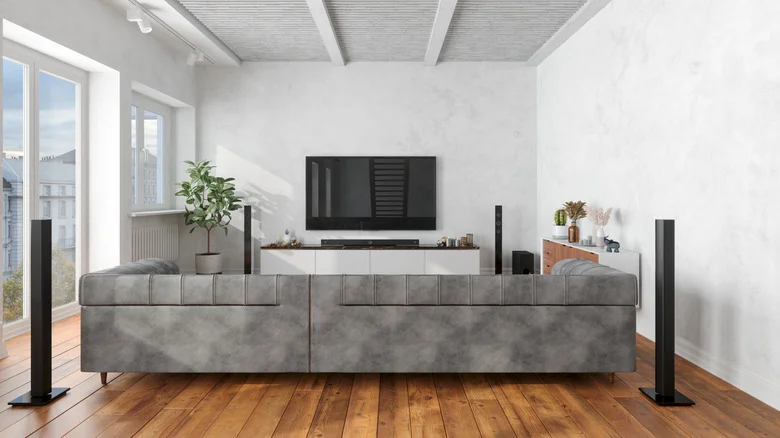 Large room with multiple speakers and a smart TV mounted on the wall.