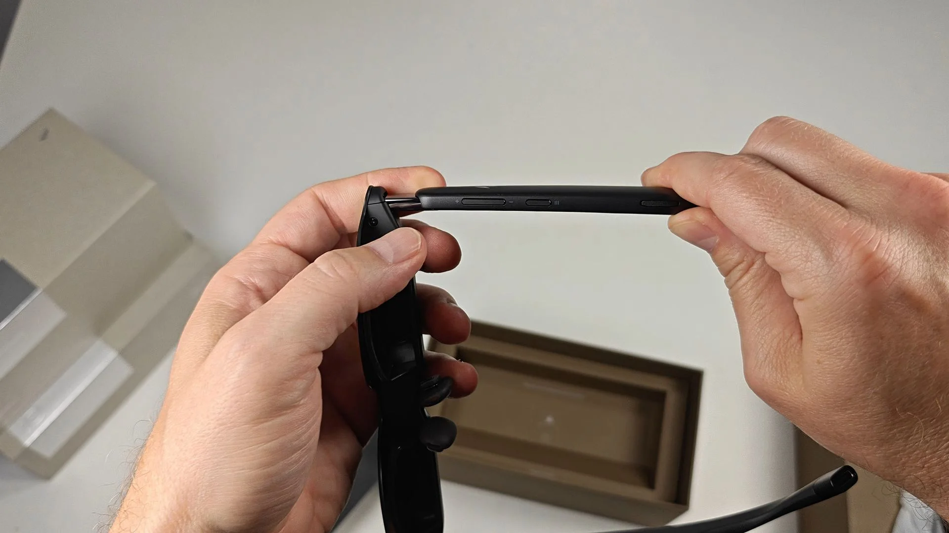 The buttons on the underside of the RayNeo GT smart glasses' left arm