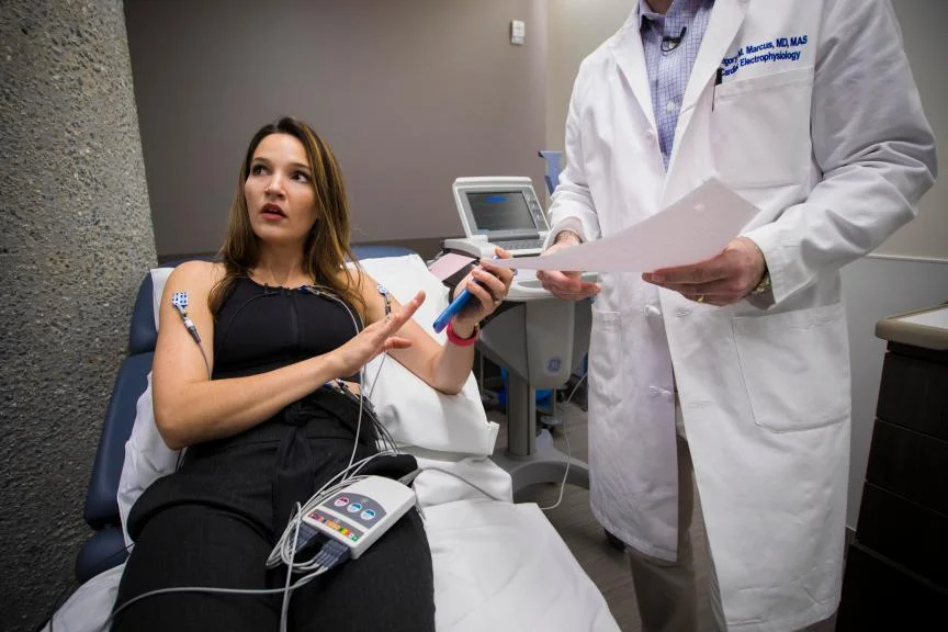 A woman learns about her irregular heartbeat at a doctor's office.