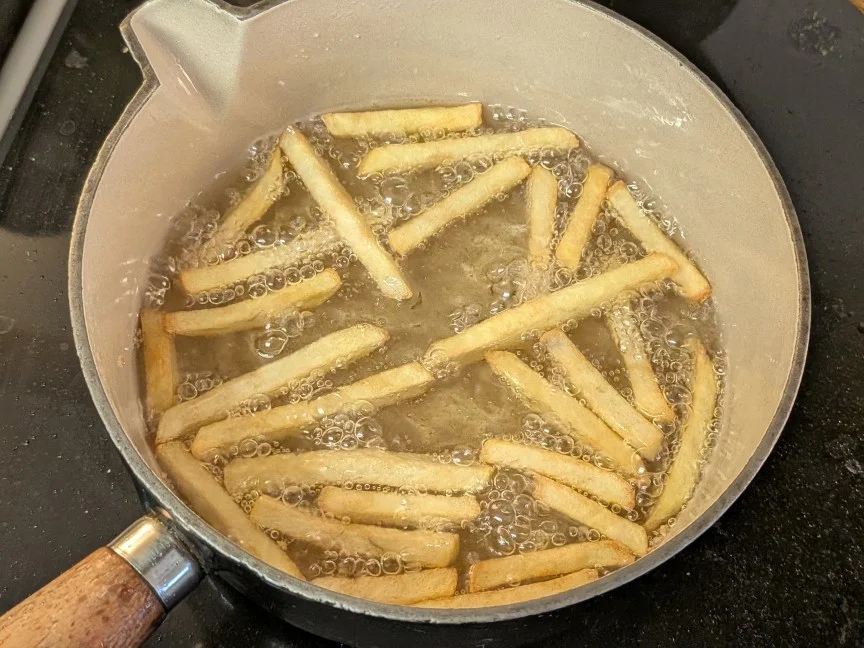 french fries in pot cooking in oil