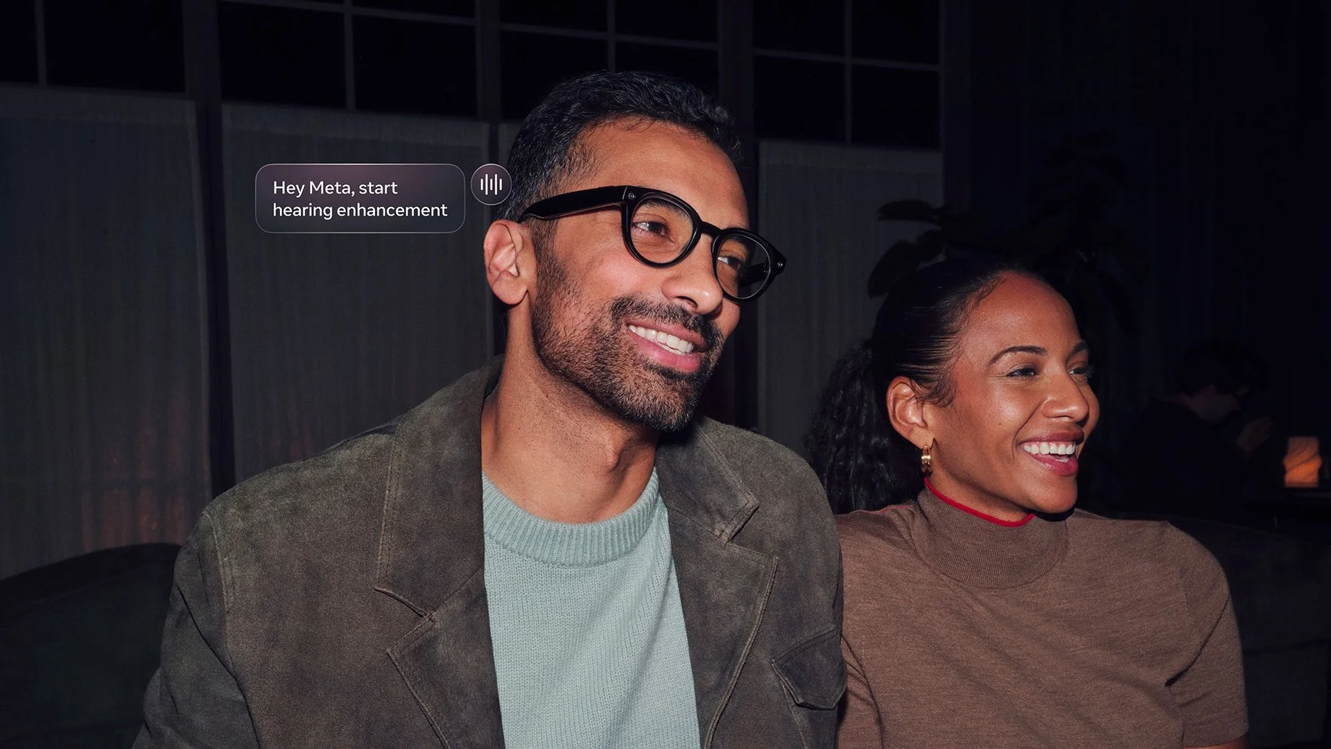 An official lifestyle image of a man asking Meta AI glasses to begin hearing enhancement