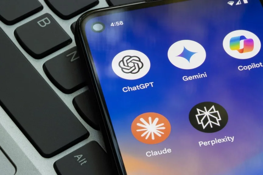 A phone with AI apps on it lays on a keyboard.